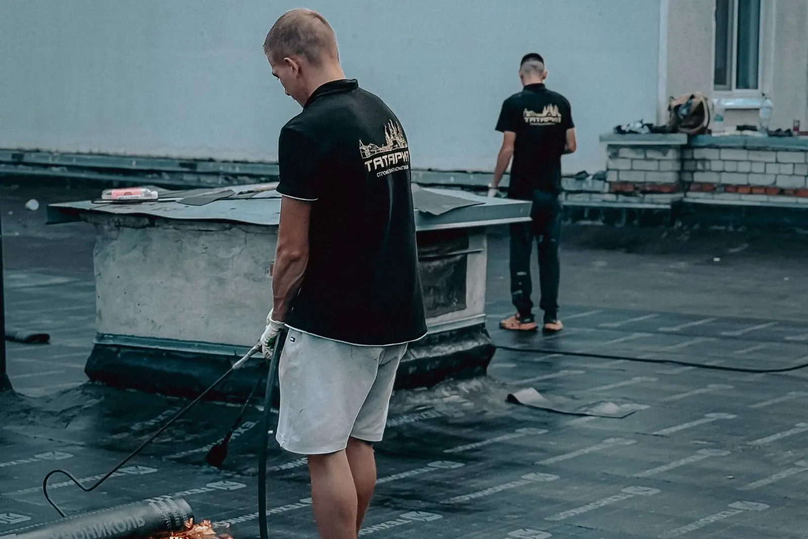 Roofing contractors working on a flat membrane roof